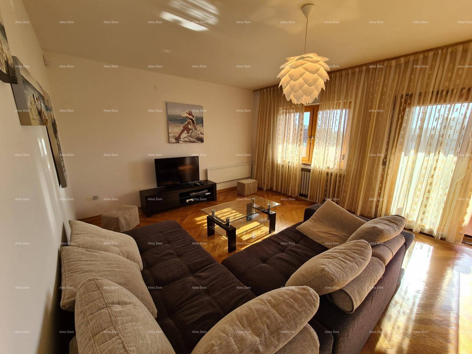 Helles Wohnzimmer mit Parkettboden, bequemer Couch und dekorativer Deckenleuchte.