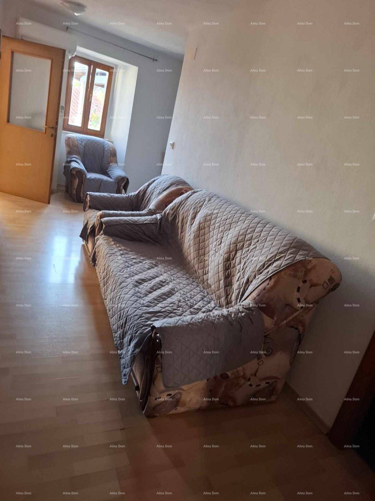 Wohnzimmer mit hellem Laminatboden und einem bequemen Sofa, das zum Entspannen einlädt.