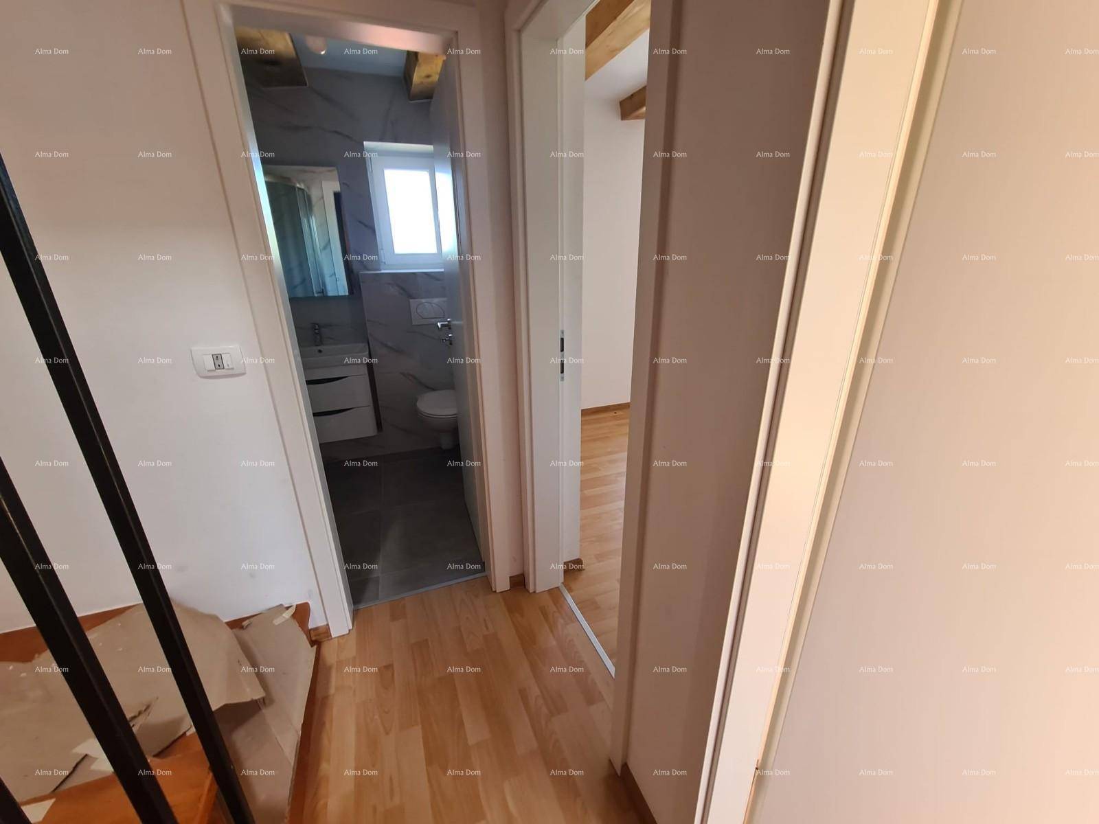 Flur mit hellem Laminatboden, der zu verschiedenen Zimmern und einem Badezimmer führt.