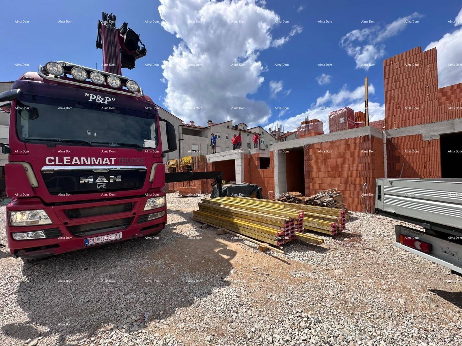 Baustelle mit Lieferwagen, Baumaterialien und im Bau befindlichen Ziegelwänden unter blauem Himmel.