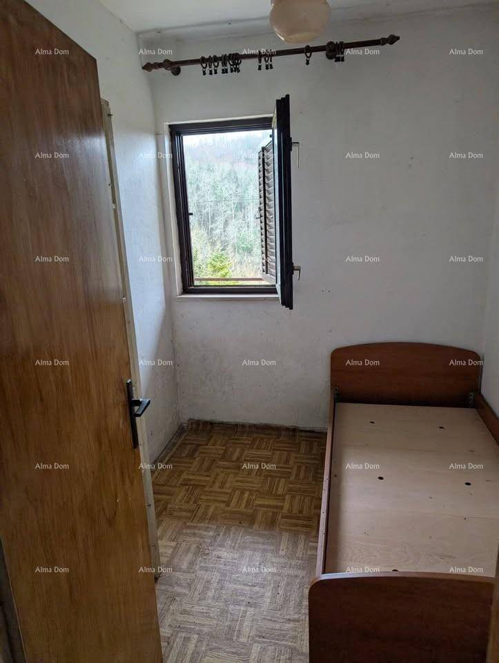 Kleines Schlafzimmer mit Einzelbett, Fenster mit Blick ins Grüne und gemustertem Bodenbelag.