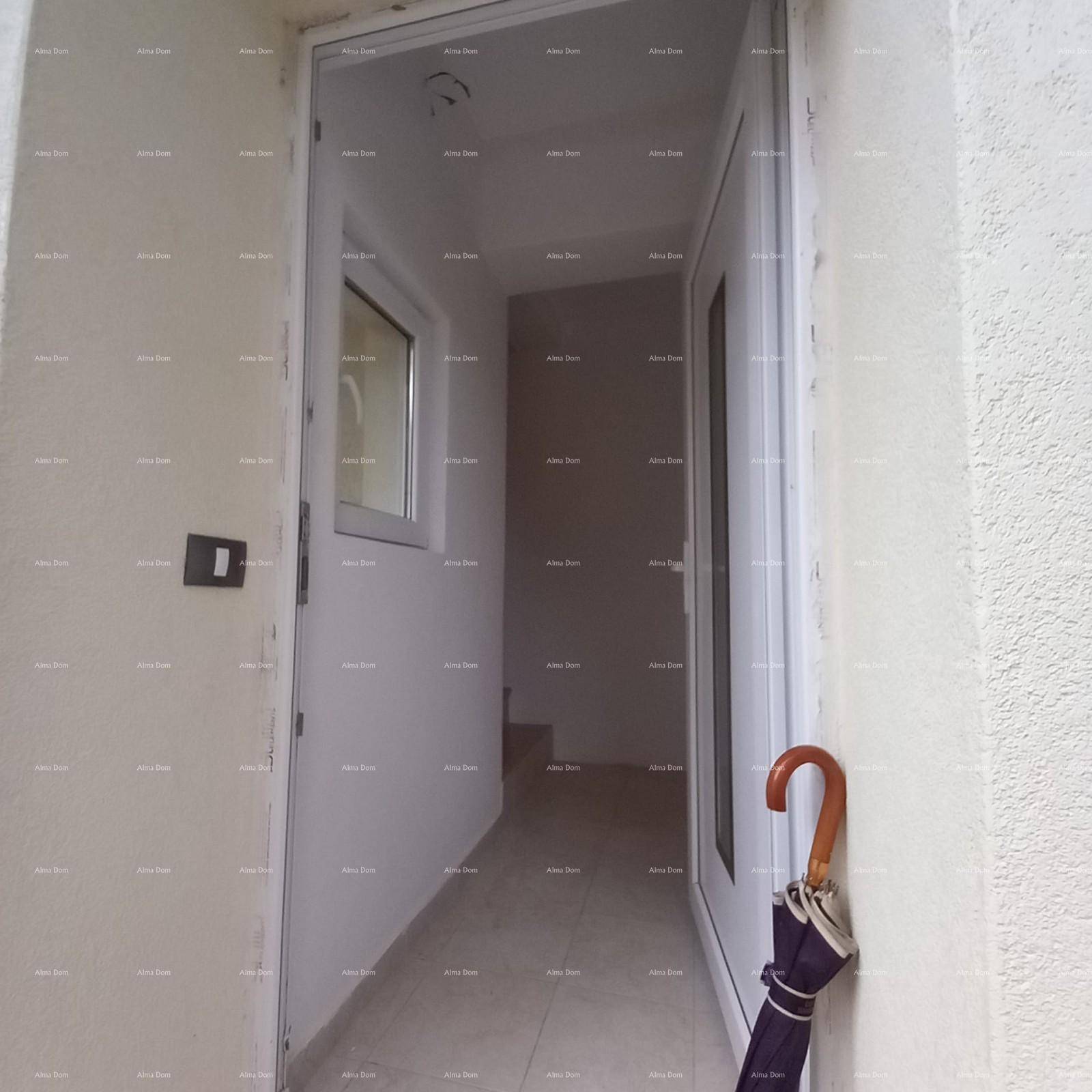 Heller Eingangsbereich mit Fliesenboden und einer Tür, die zu einem Treppenhaus führt.
