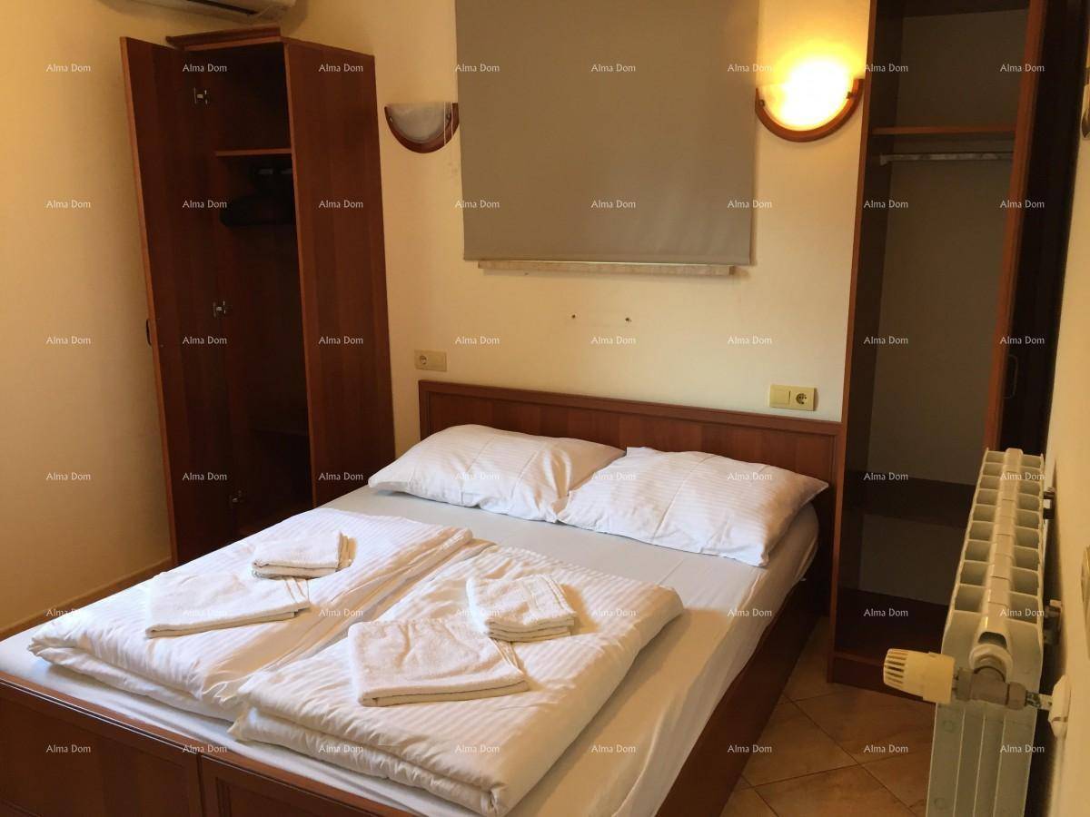 Gemütliches Schlafzimmer mit Doppelbett, offenem Kleiderschrank und Heizkörper an der Wand.