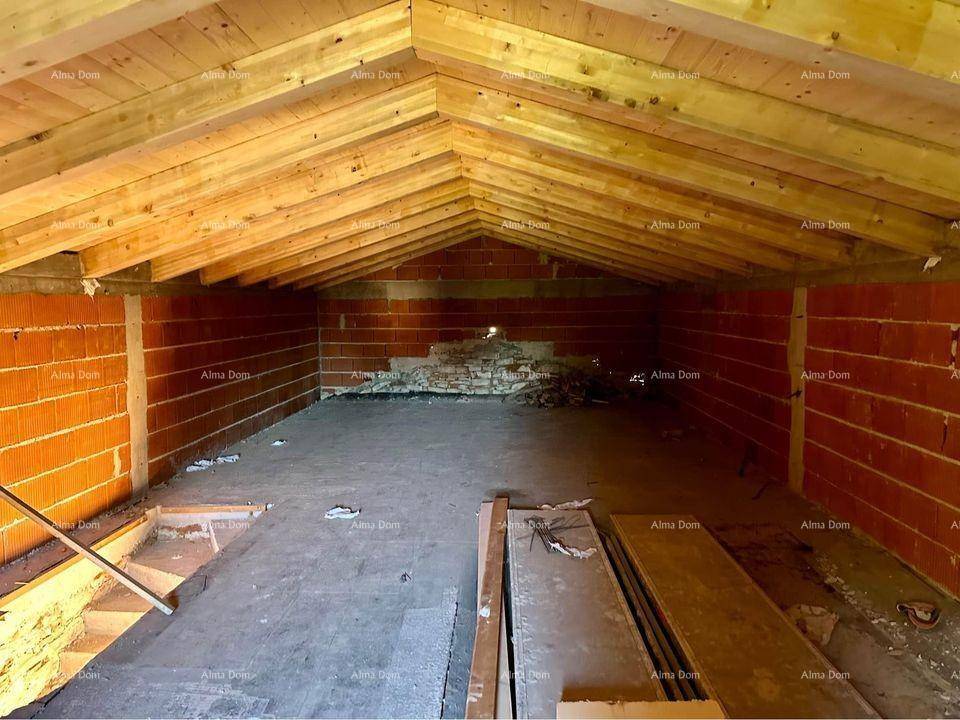 Dachboden im Rohbau mit sichtbaren Holzbalken und Ziegelwänden, bereit für den Ausbau.