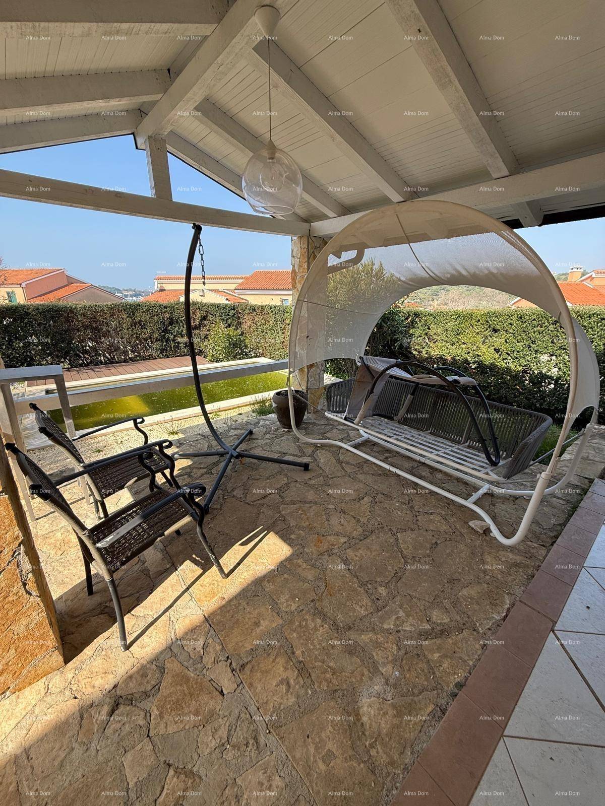 Überdachte Terrasse mit bequemen Sitzmöbeln und Blick auf die grüne Umgebung.
