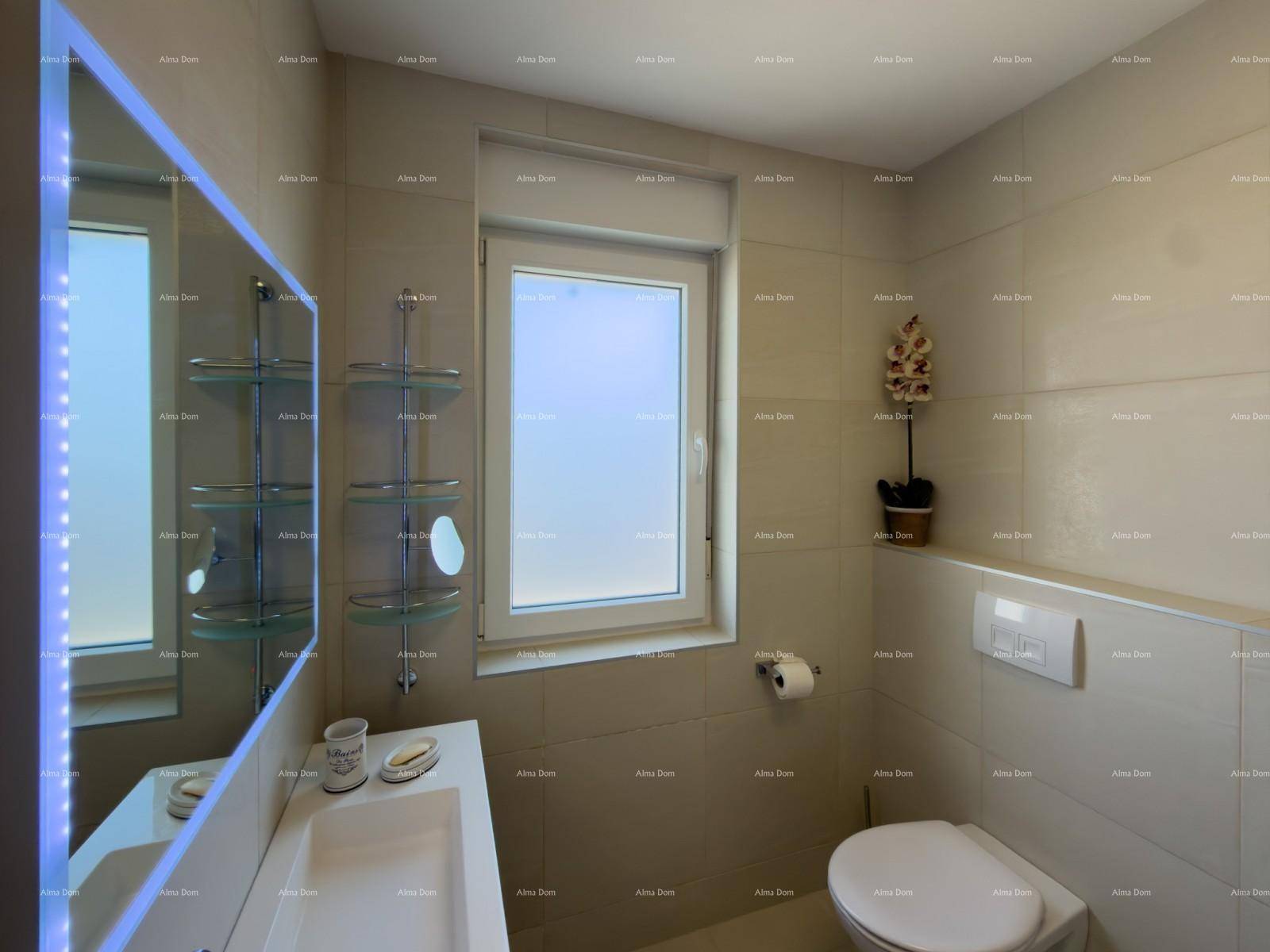 Helles Badezimmer mit beigefarbenen Fliesen, modernem Waschtisch und Fenster für Tageslicht.