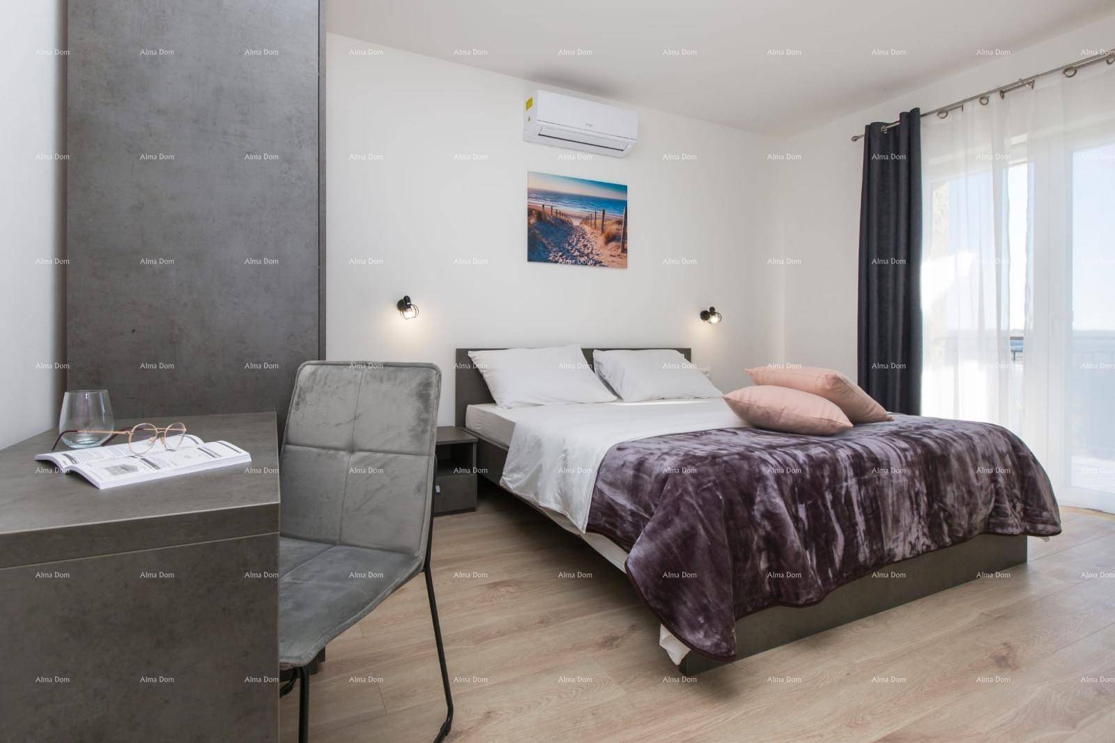 Helles Schlafzimmer mit Doppelbett, Klimaanlage und Zugang zu einem Balkon oder einer Terrasse.