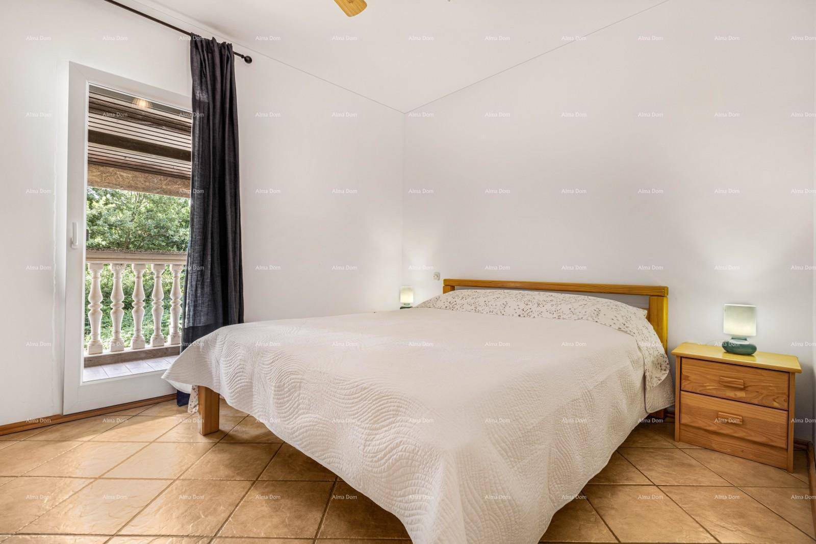 Schlafzimmer mit Doppelbett, Fliesenboden und Zugang zu einem französischen Balkon.