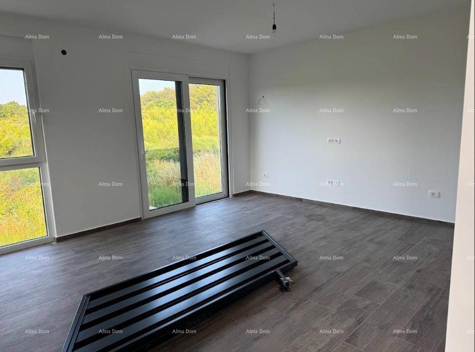 Lichtdurchfluteter Raum mit großen Fenstern, dunklem Fliesenboden und weitem Blick ins Grüne.