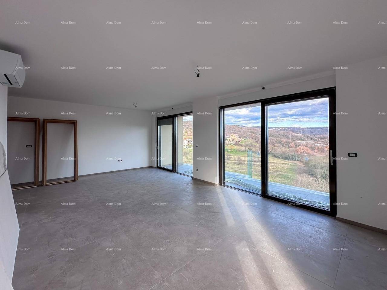 Offener Wohnbereich im Rohbau mit großen Fenstern und weitem Blick ins Grüne.