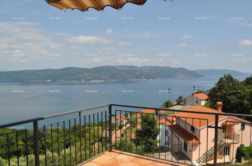 Sonniger Terrassenbereich mit Markise und weitem Blick auf das Meer und die umliegende Landschaft.