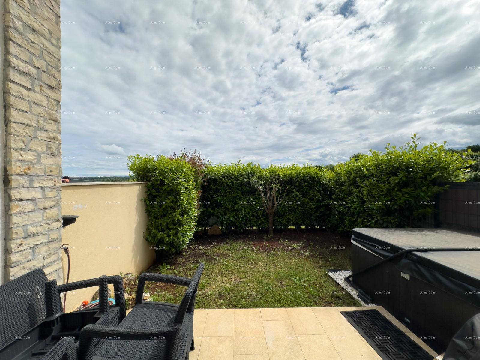 Terrasse mit Sitzgelegenheiten, Whirlpool und Blick auf die grüne Umgebung.