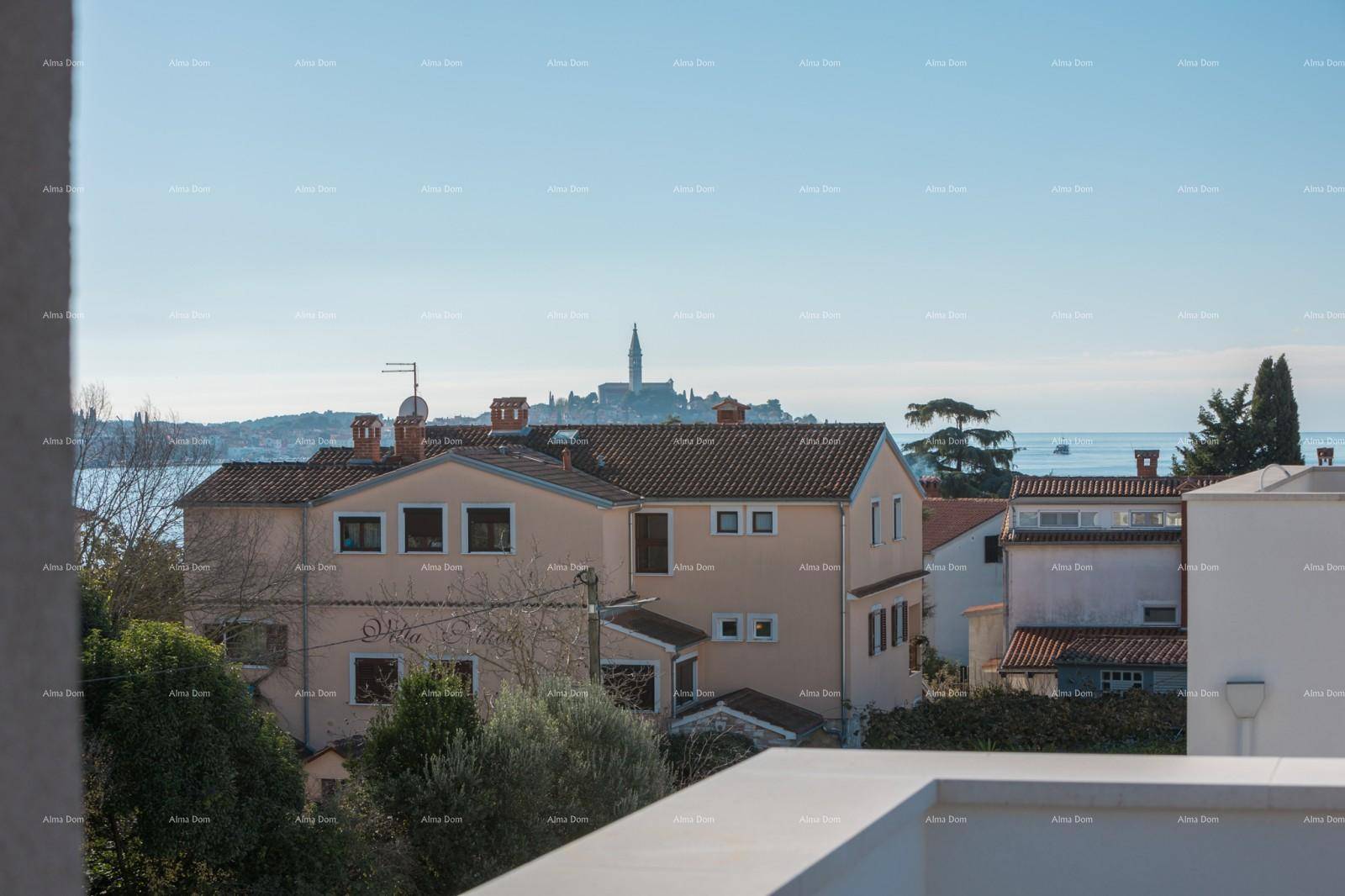 Weitblick über eine Küstenstadt mit Meer und historischem Kirchturm an einem sonnigen Tag.