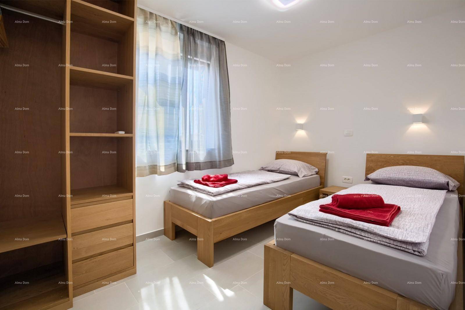 Schlafzimmer mit zwei Einzelbetten, offenem Holzregal und Fenster mit Vorhängen für natürliche Beleuchtung.