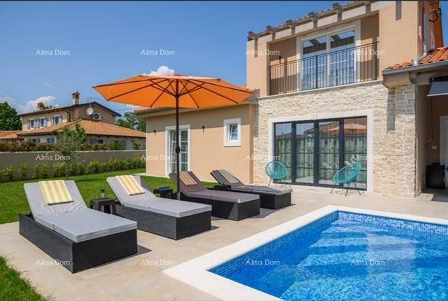Sonniger Poolbereich mit bequemen Liegestühlen, Sonnenschirm und Blick auf die Hausfassade mit Balkon.