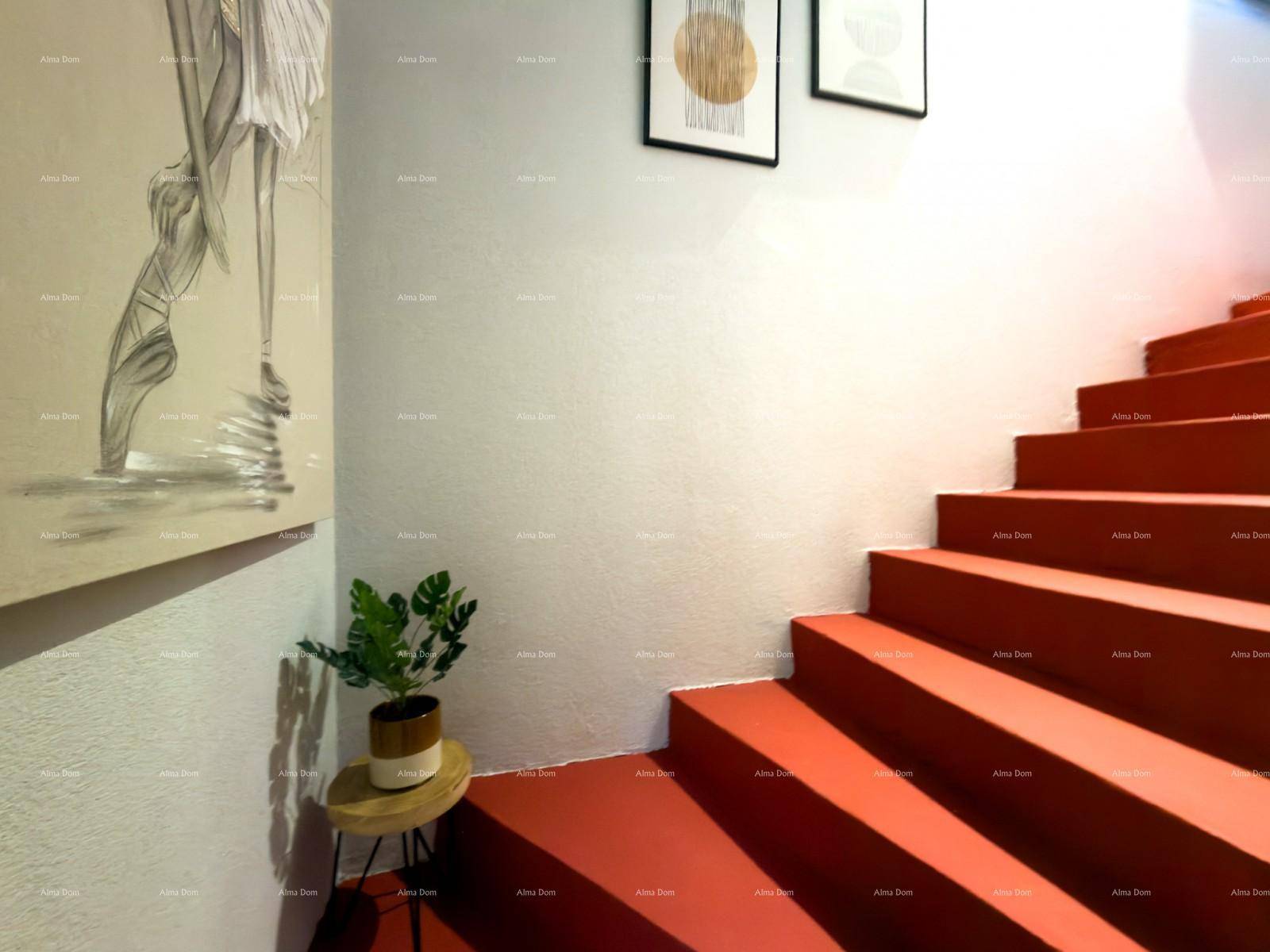 Innenliegende Treppe mit leuchtend roten Stufen und moderner Wanddekoration.