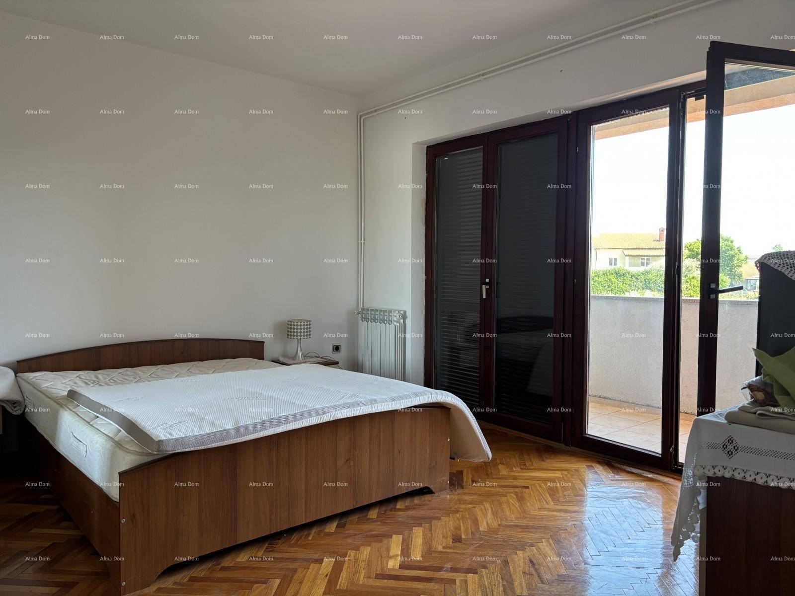 Helles Schlafzimmer mit Parkettboden, Doppelbett und direktem Zugang zum Balkon.