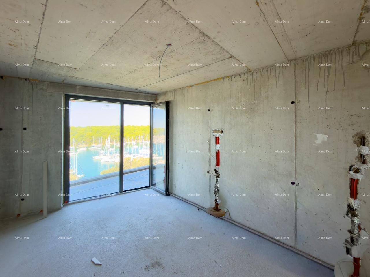 Unfertiger Raum mit Betonwänden und großen Schiebetüren, die einen weiten Blick auf den Yachthafen ermöglichen.
