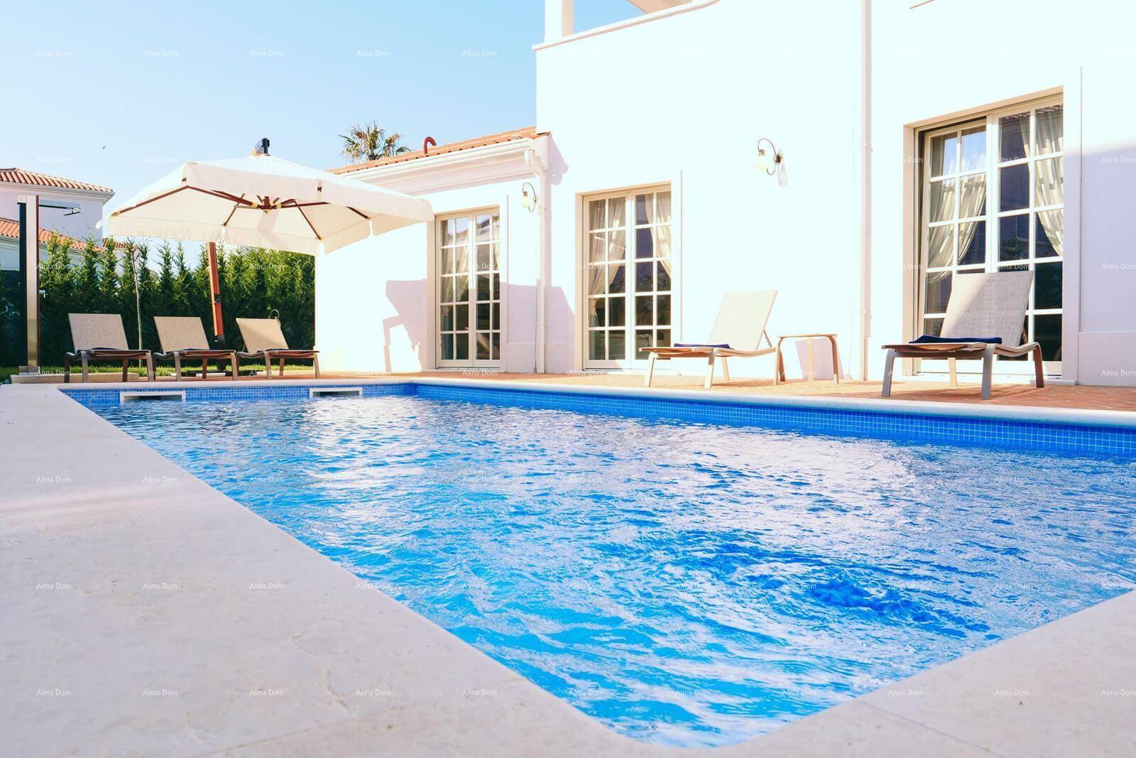 Erfrischender Pool mit blauen Fliesen und bequemen Sonnenliegen auf der umliegenden Terrasse.