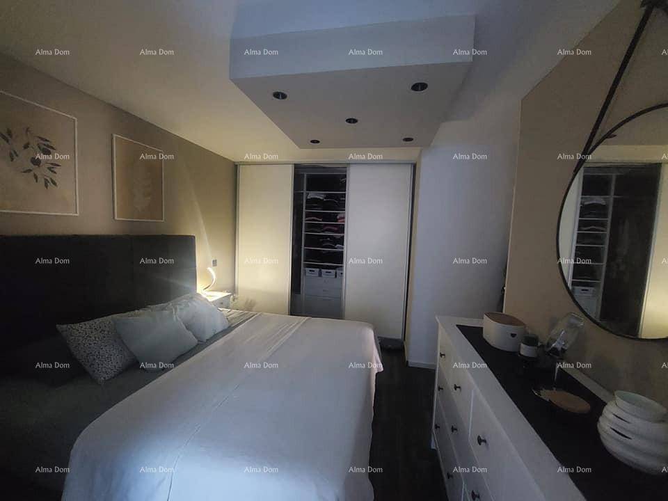 Schlafzimmer mit großem Bett, Kommode, Spiegel und einem praktischen Einbauschrank mit Schiebetüren.