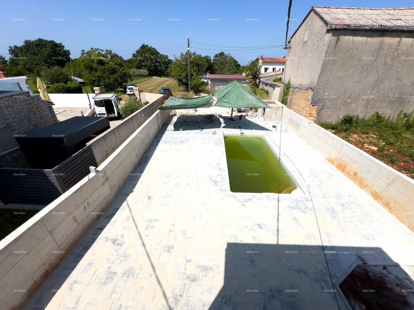 Weitläufiger Außenbereich mit Pool in Bau, umgeben von Mauern und Blick auf die ländliche Umgebung.