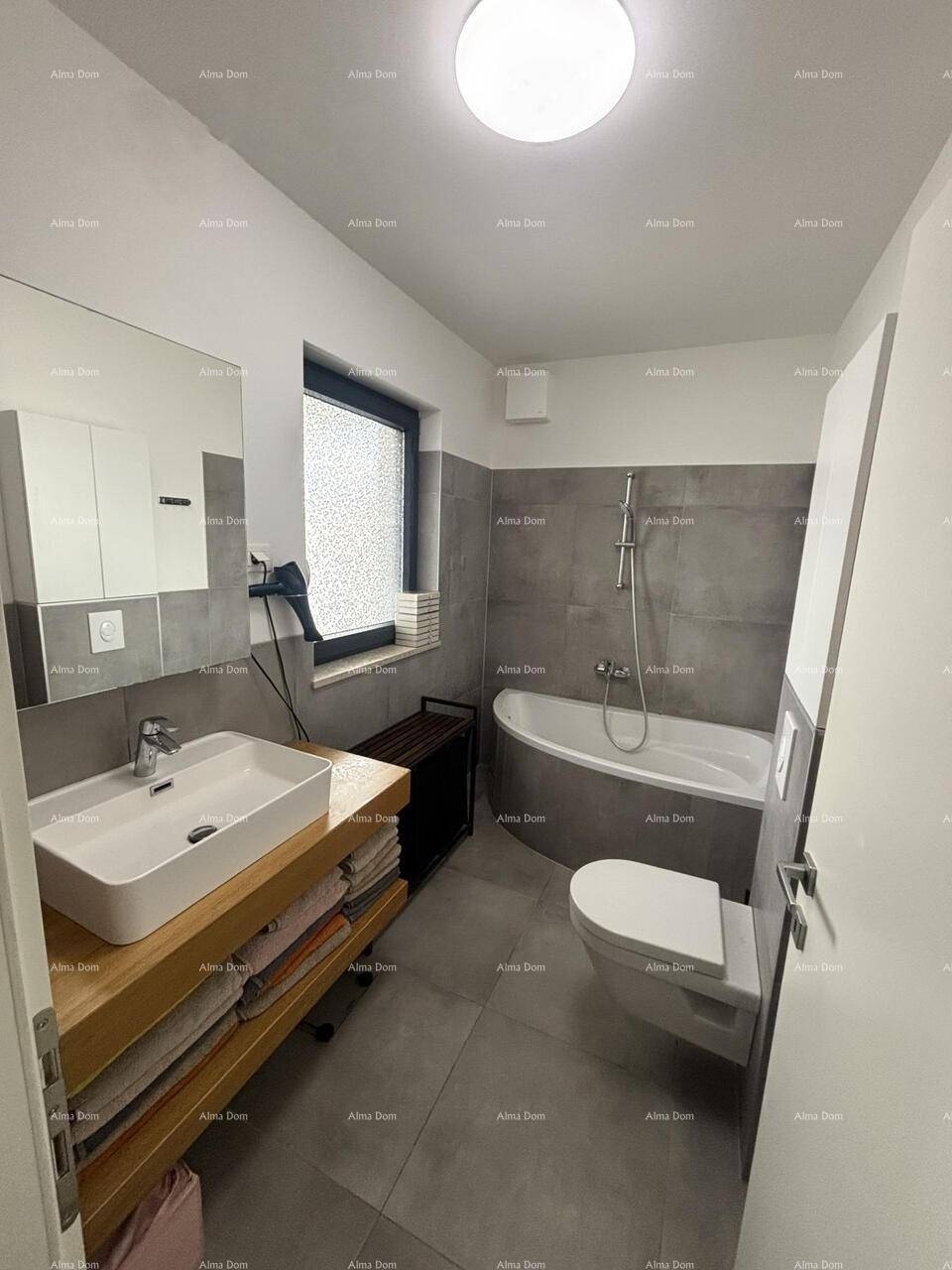 Modernes Badezimmer mit Badewanne, Einzelwaschbecken und Fenster.