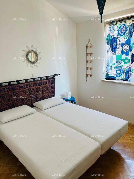 Schlafzimmer mit zwei Einzelbetten, dekorativem Kopfteil und bunten Vorhängen am Fenster.