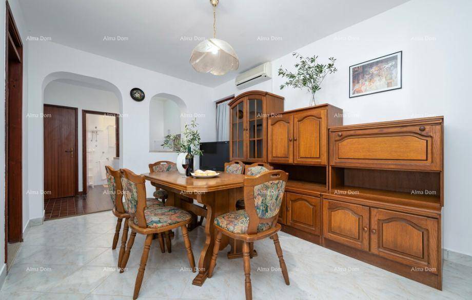 Traditioneller Essbereich mit Holztisch, passenden Stühlen und einem Sideboard, ausgestattet mit Klimaanlage.