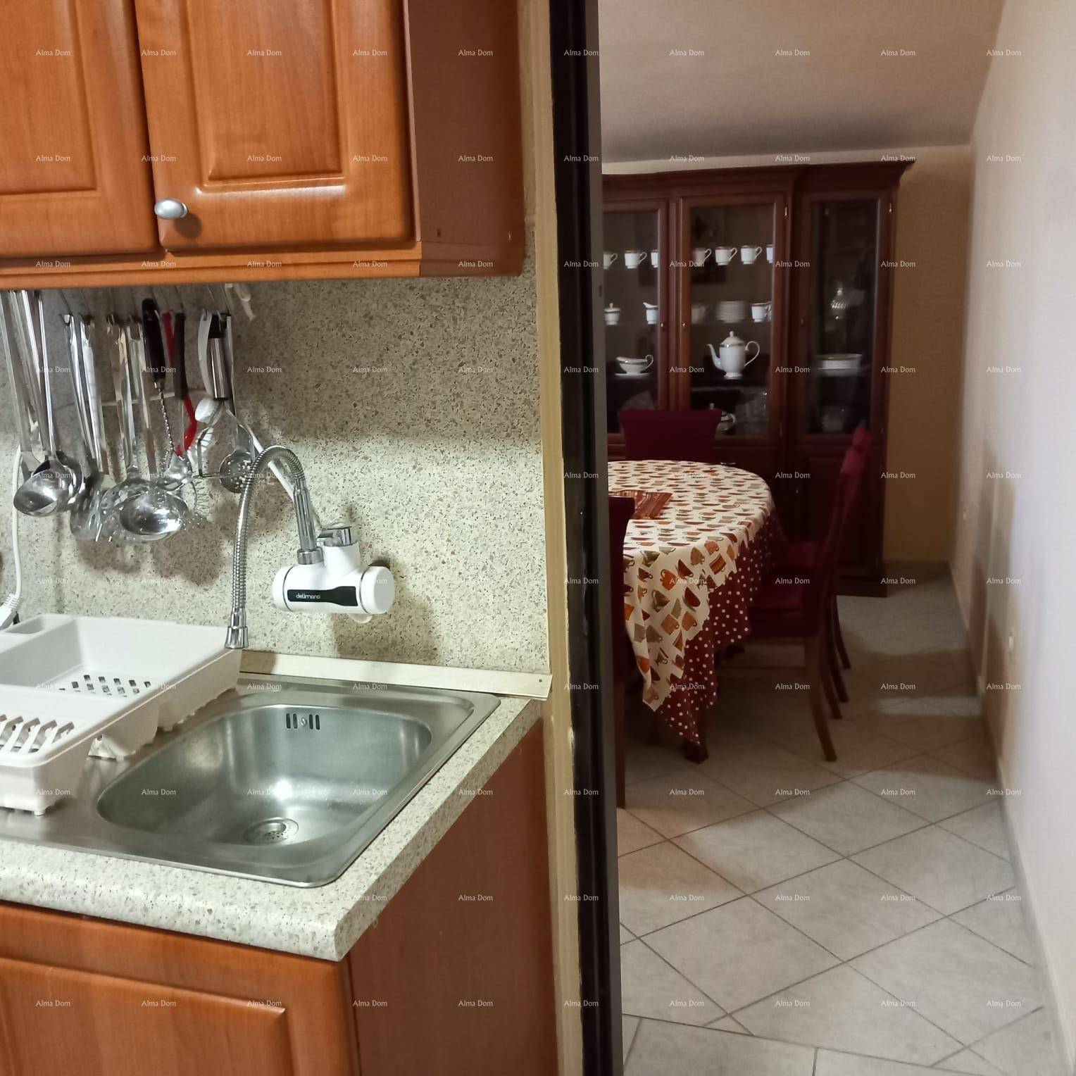 Küchenbereich mit Spüle und Durchblick zum angrenzenden Esszimmer mit traditionellen Möbeln.