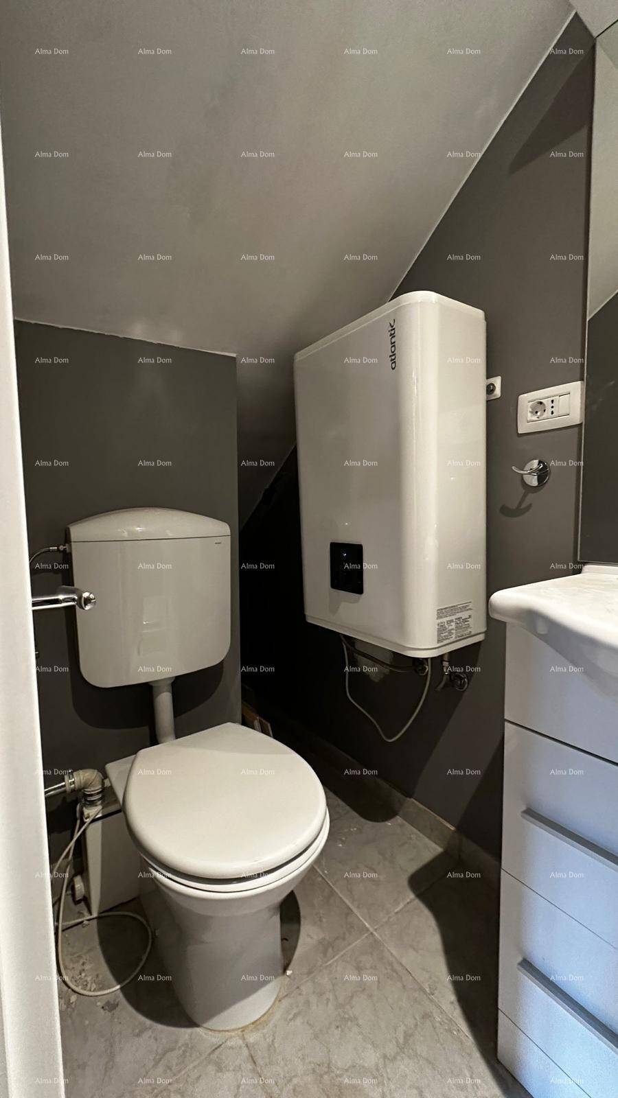 Modernes WC mit Wand-WC, Waschbeckenunterschrank und Boiler an der Wand.