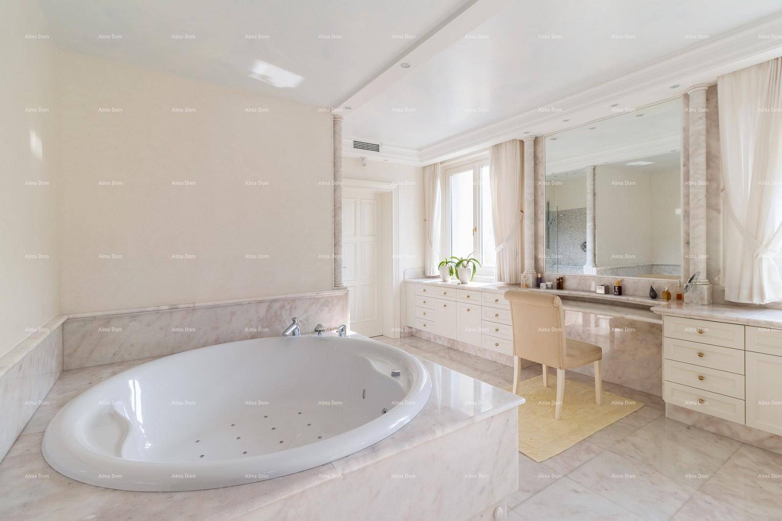 Elegantes Badezimmer mit ovaler Badewanne, Marmoroberflächen und einem Schminktisch.