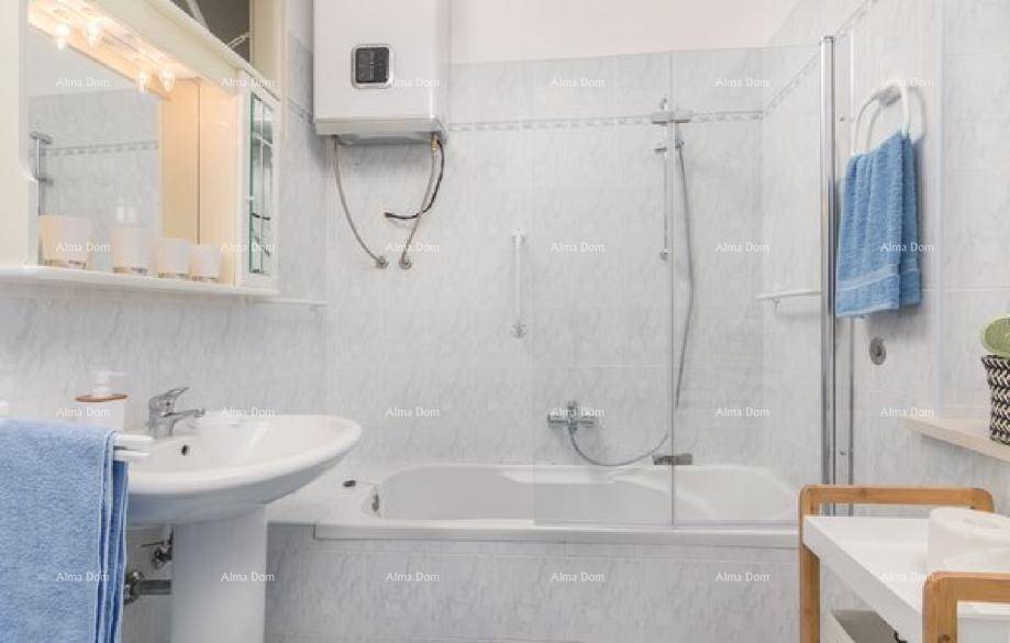 Badezimmer mit Badewanne, Duschfunktion, Waschbecken und Spiegelschrank über dem Waschtisch.