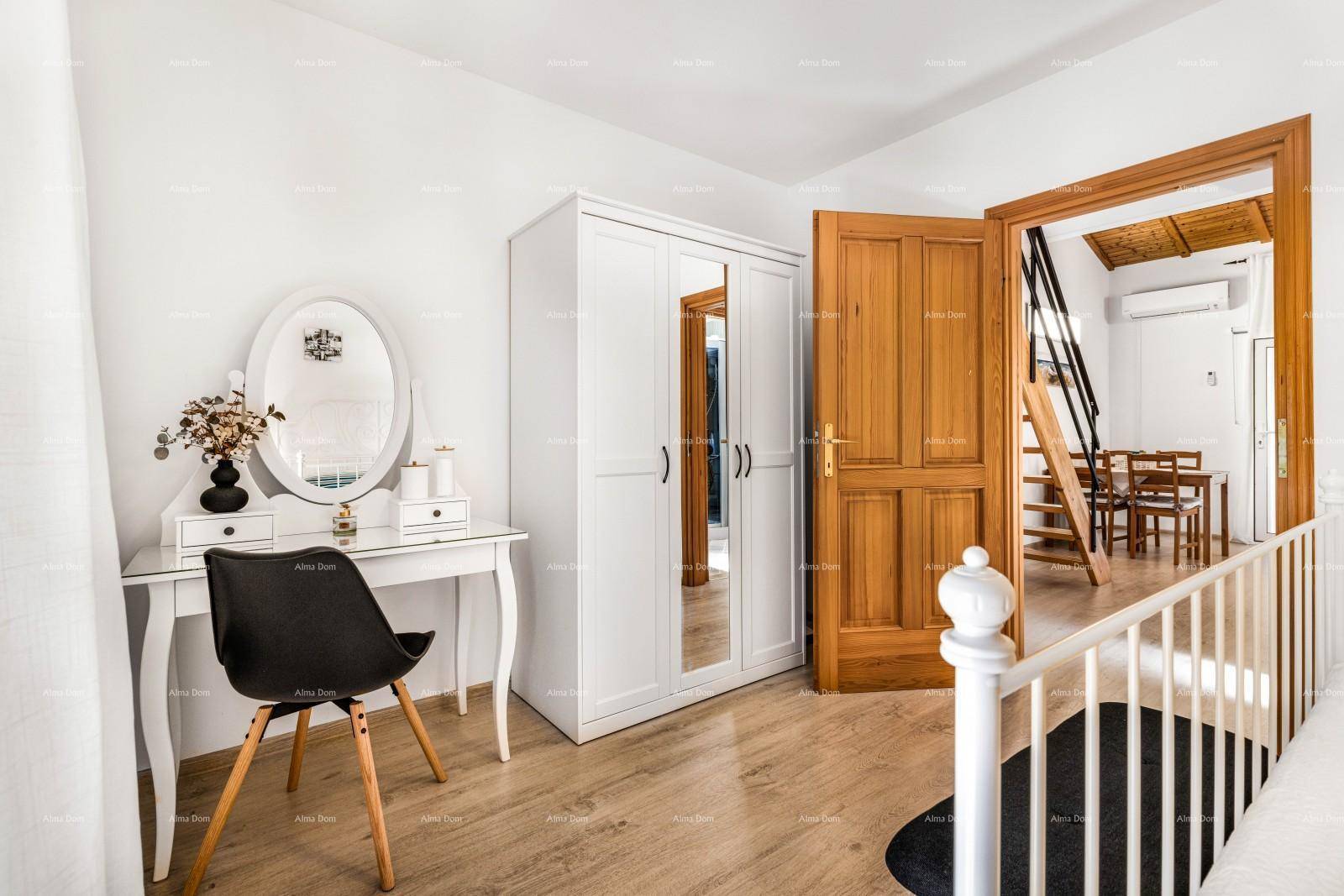 Schlafzimmer mit weißem Schminktisch, Kleiderschrank und Blick auf die Holztreppe.