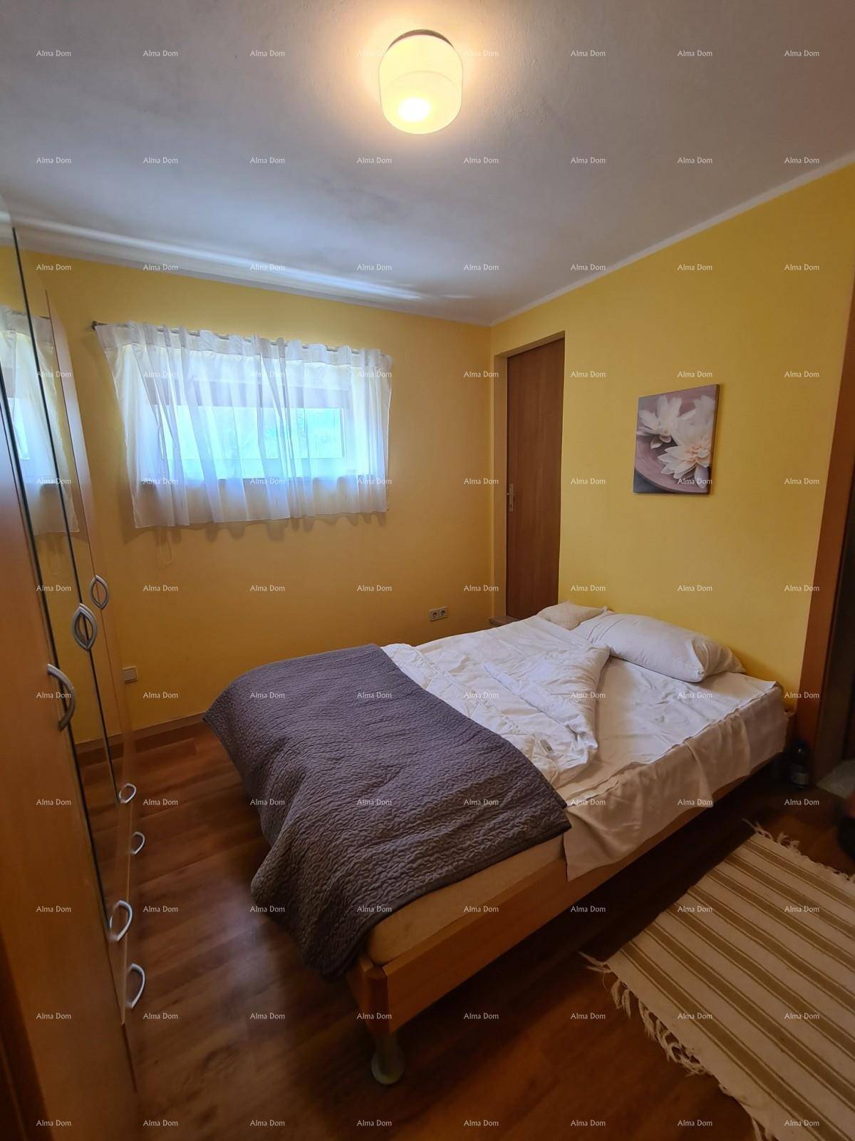 Helles Schlafzimmer mit Holzbett, gelben Wänden und einem Fenster mit weißen Vorhängen.