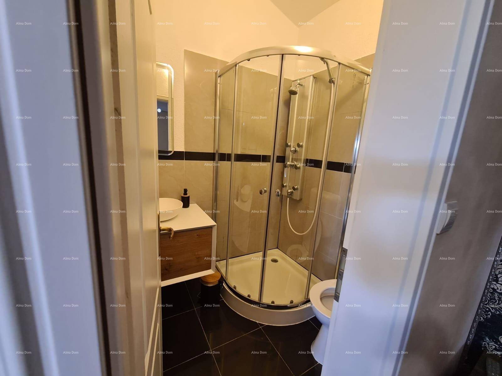 Modernes Badezimmer mit Duschkabine, Waschbecken und dunklen Bodenfliesen.