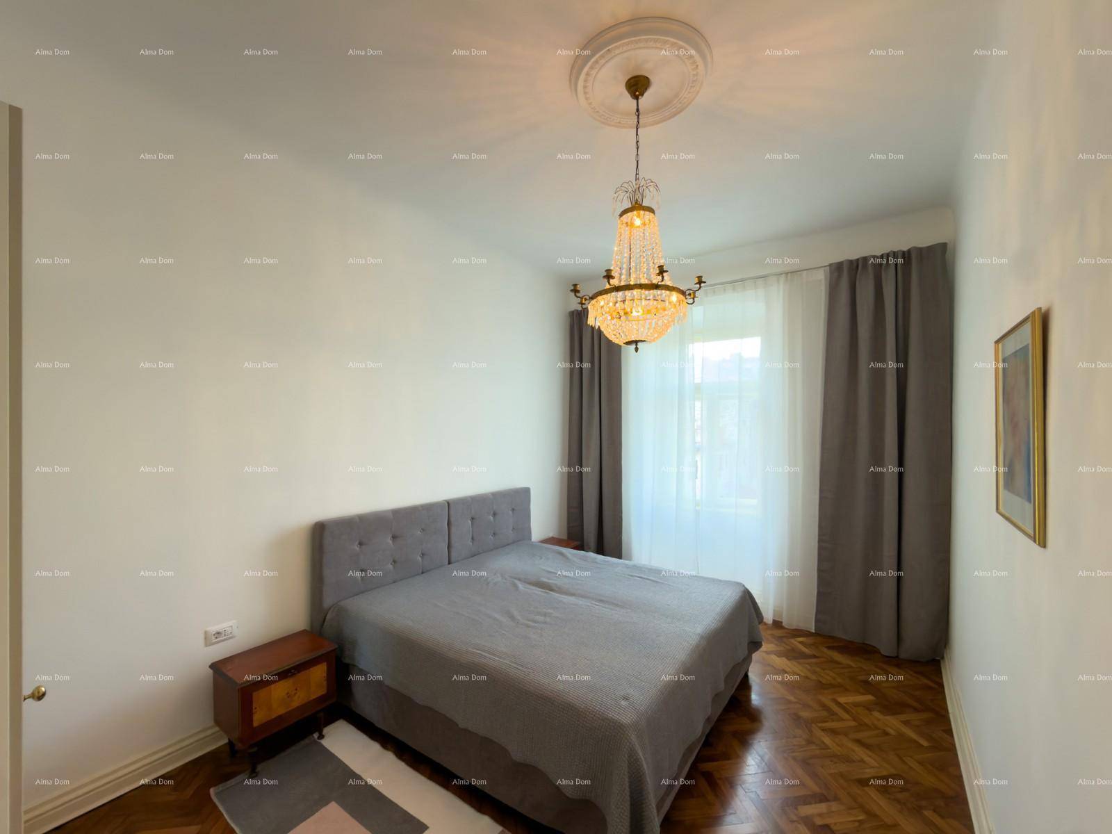 Helles Schlafzimmer mit Doppelbett, Holzboden und einem Fenster, das viel Tageslicht spendet.
