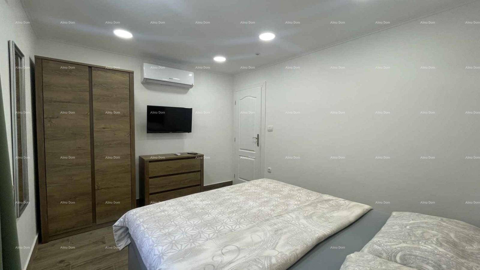 Schlafzimmer mit modernem Doppelbett, Klimaanlage und schlichten, hellen Wänden.