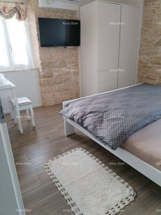 Helles Schlafzimmer mit Steinwand, Fliesenboden und modernem Bett, ausgestattet mit Klimaanlage für Komfort.