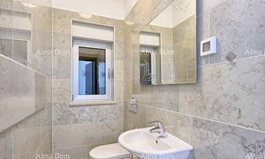 Modernes Badezimmer mit Fenster, Waschbecken, Spiegel und WC in hellen Fliesen.