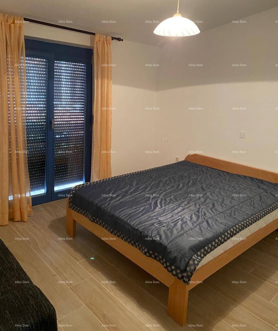 Schlafzimmer mit Holzbett und Fenster mit Rollladen, das viel natürliches Licht hereinlässt.