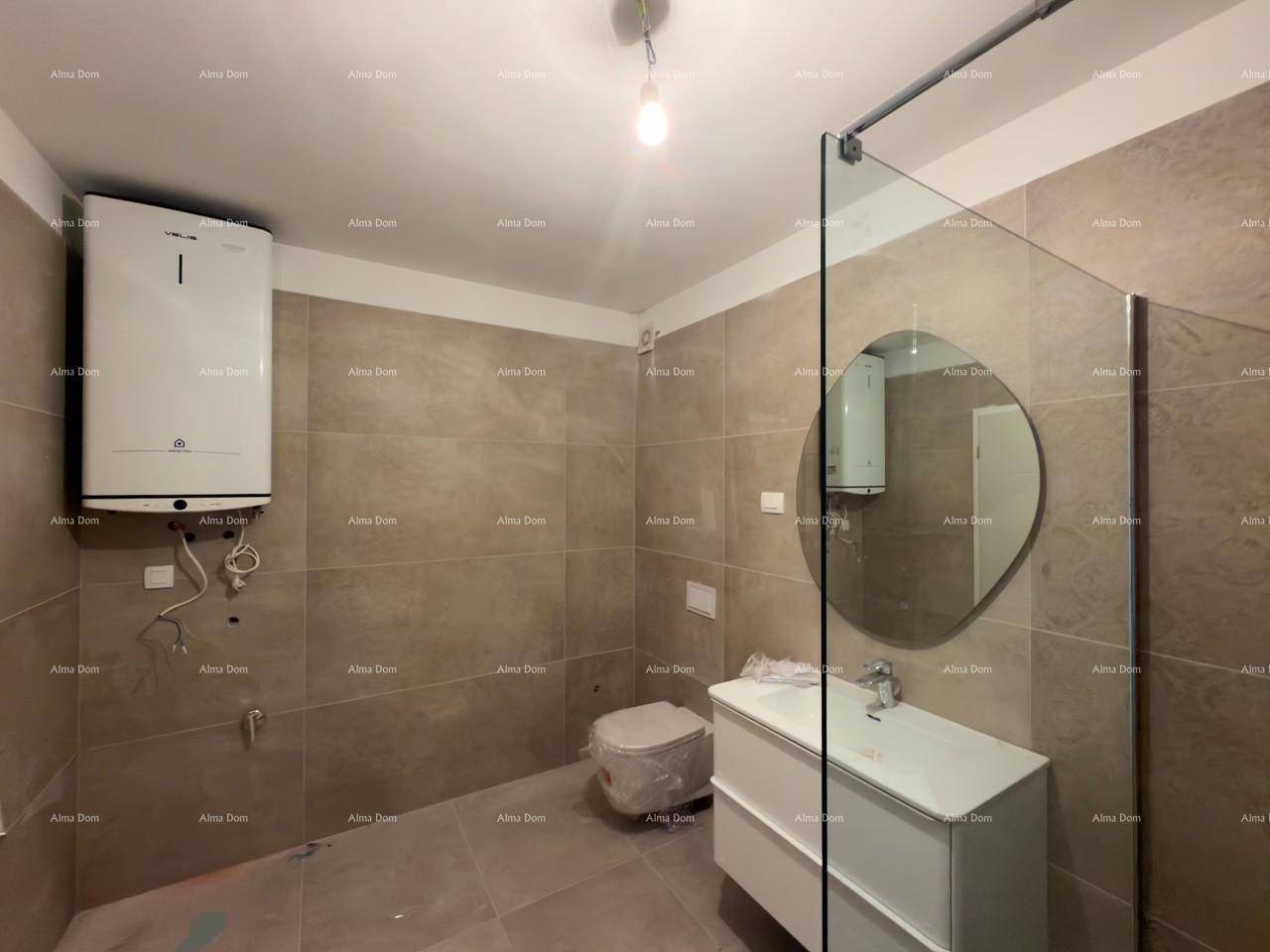 Modernes Badezimmer mit Wand-WC, Waschbecken und Warmwasserbereiter an der Wand.