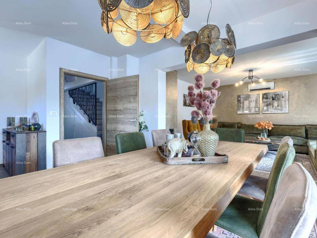 Einladender Essbereich mit großem Holztisch, dekorativen Leuchten und Zugang zum Wohnzimmer.