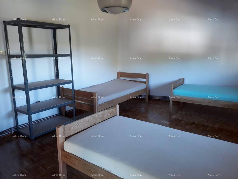 Schlafzimmer mit drei Einzelbetten und einem Metallregal, ideal als Gästezimmer.