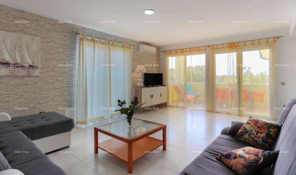 Helles Wohnzimmer mit bequemen Sofas, Fliesenboden und Zugang zu einem Balkon.