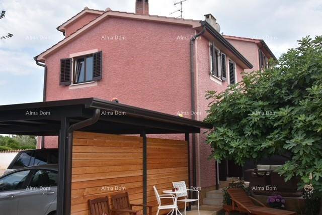 Hausfassade mit überdachtem Carport und gemütlichem Sitzbereich im Freien.