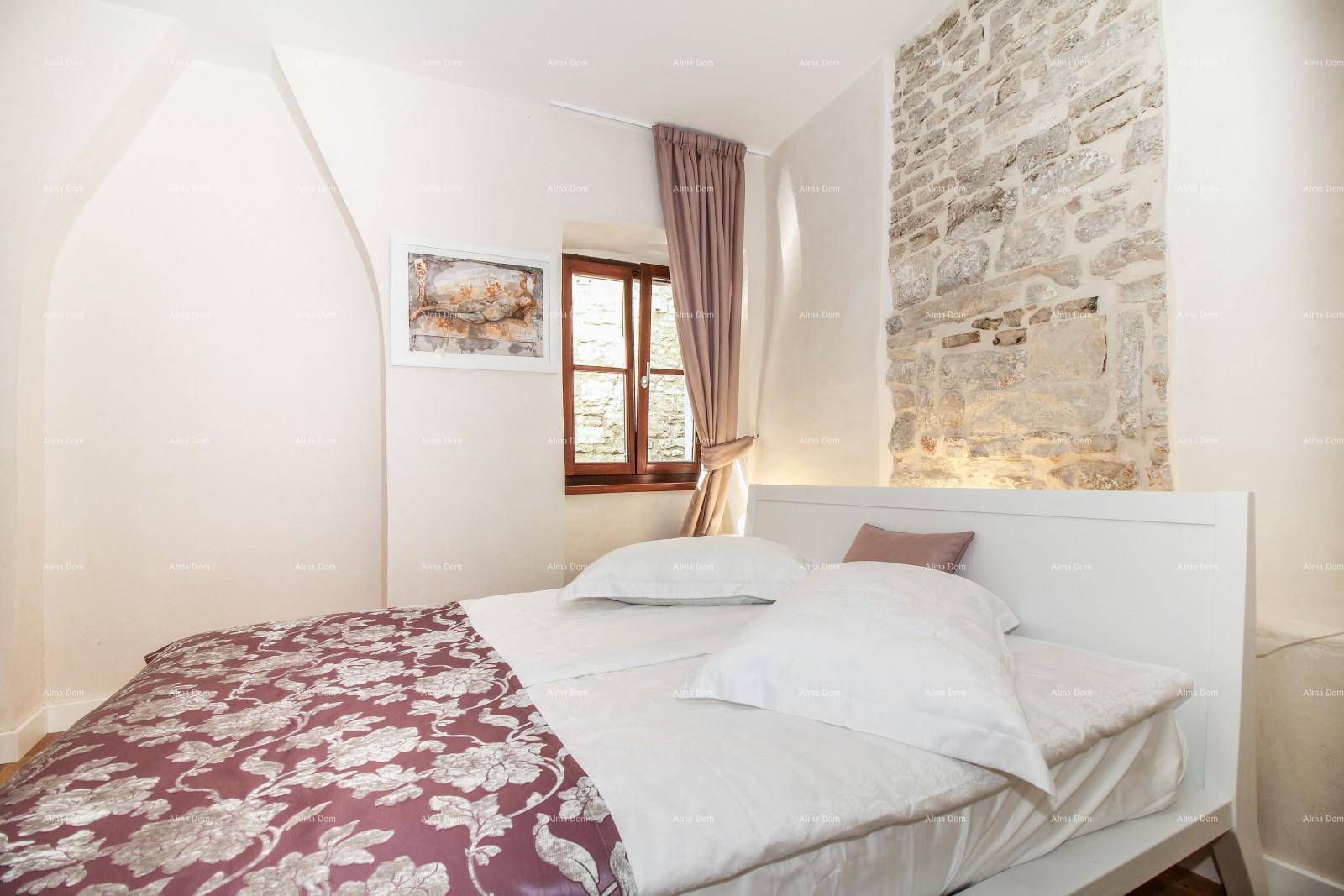Helles Schlafzimmer mit Holzboden, Doppelbett und einem Fenster, das viel Tageslicht spendet.