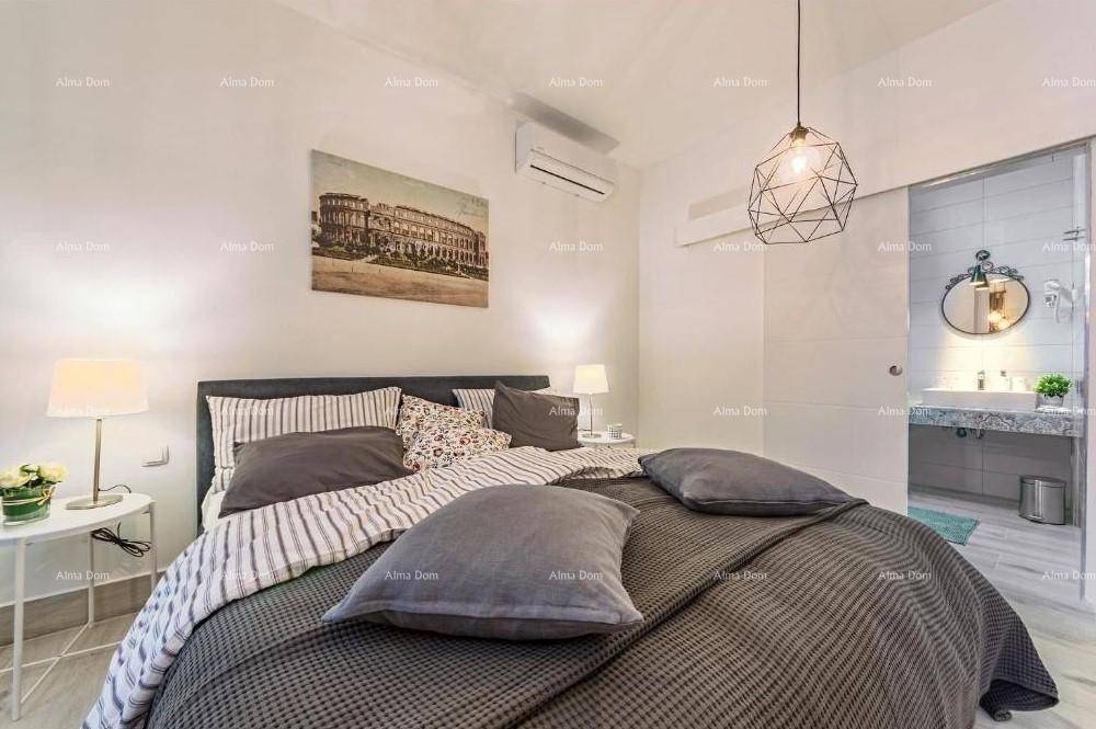 Helles Schlafzimmer mit Doppelbett, Klimaanlage und Blick auf das angrenzende Badezimmer.