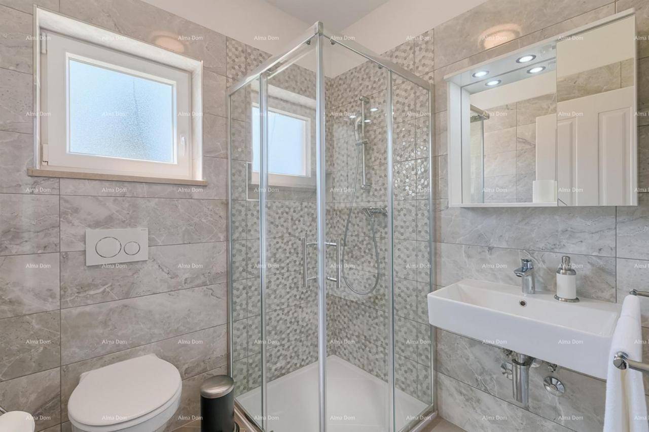 Modernes Badezimmer mit Duschkabine, WC, Waschbecken und hellen Fliesen.