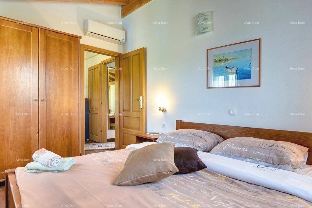 Schlafzimmer mit Holzschrank, Klimaanlage und Blick in den angrenzenden Flur.