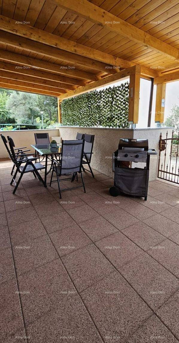 Große überdachte Terrasse mit Grillbereich und Esstisch für gesellige Stunden im Freien.
